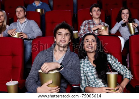 Young people are closely watching a movie at the cinema