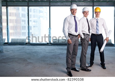Young men in shirts and helmets on a construction site