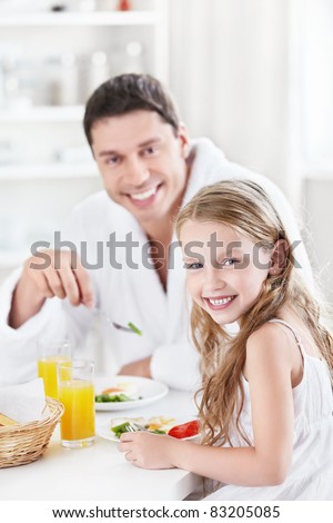Dad and daughter eating breakfast in the kitchen