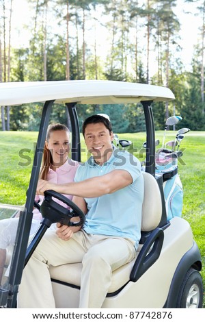 Smiling couple in the car for golf