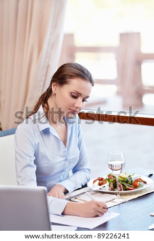 Woman signs a document in a restaurant