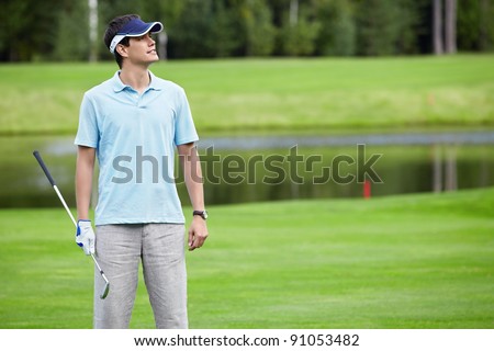 A young man with a golf club on the field