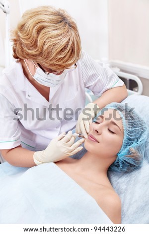 The doctor makes a cosmetic procedure