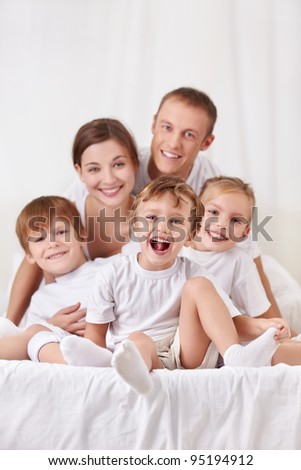 Happy family with children in the bedroom
