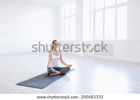 Young woman doing yoga in studio
