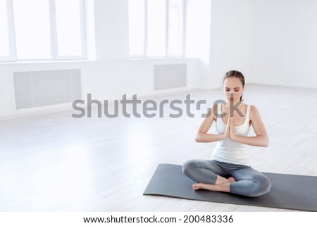 Attractive girl doing yoga in studio