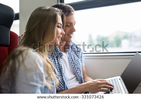 Young couple with a laptop on the train