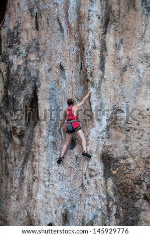 Woman climbing on the rock route summer (Railay Beach, Krabi province Thailand).