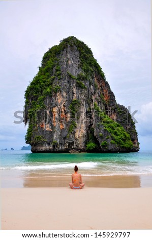 woman alone sit on the beach looking sea and island (Railay, Krabi province Thailand).