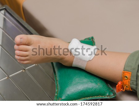 child boy with bandage on leg and lying down hospital bed.