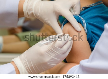 Doctor give injection of vaccine to boy\'s arm.