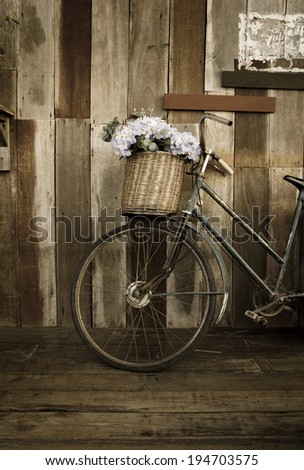 Old ladies bicycle leaning against a wooden plank.