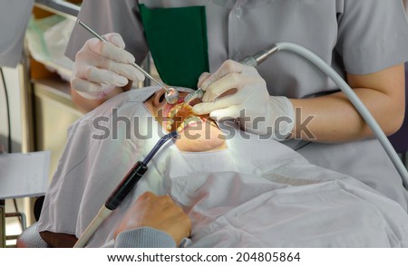 The doctor cleaning the teeth patient with ultrasonic tool.