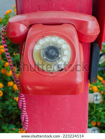 Old red phone vintage style on park.