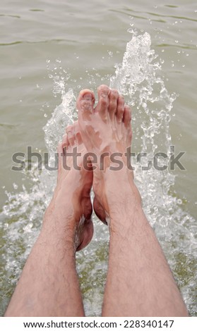 Foot of man in the water splashing