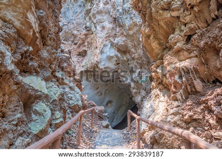 pathway underground cave with stalagmites and stalactites.