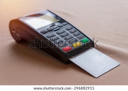 Hand Swiping Credit Card on POS terminal in Store.