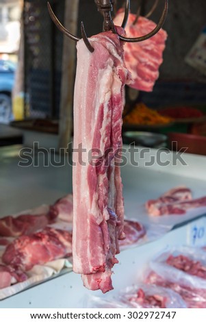 Pork meat hanged on a hooks in a market.