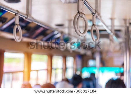 Handles on ceiling for standing passenger inside a bus.