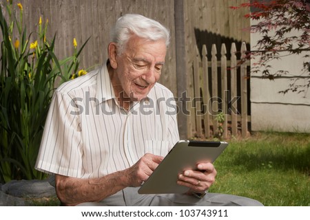 Old man senior citizen using tablet computer