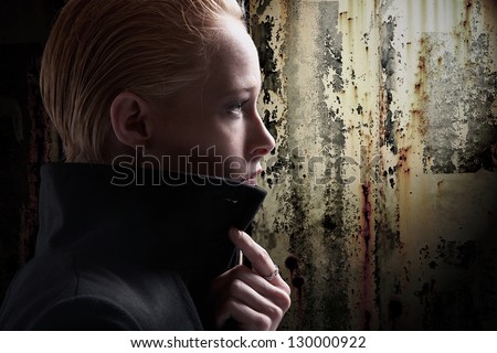 Profile of stylish young woman with dark grunge background