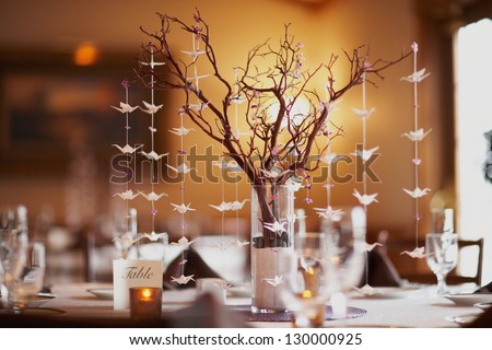 Wedding table setting with nature theme of bonsai tree and origami birds