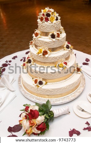 stock photo Wedding cake with bouquet of yellow and red roses
