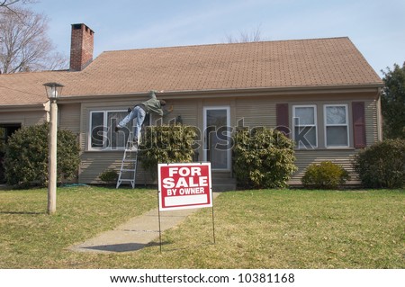 Man working on home with for sale sign