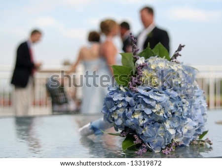 Bridal bouquet with wedding party in background, DOF focus on flowers