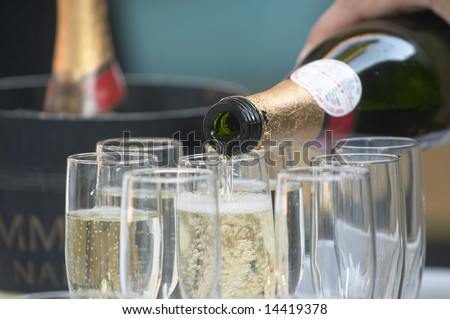 Bottle of champagne being poured into glasses
