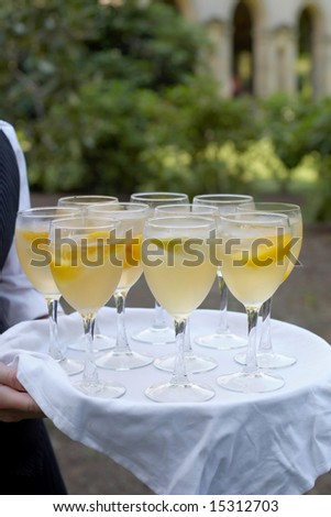 Glasses of mimosa being served at formal party