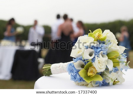 stock photo Bridal bouquet with wedding party in background 