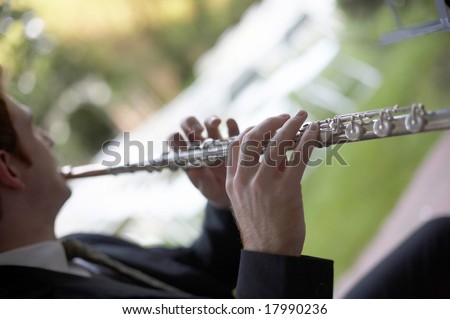 Man playing flute, DOF focus on hand