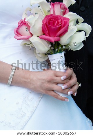 stock photo Bride holding pink and white wedding bouquet against gown