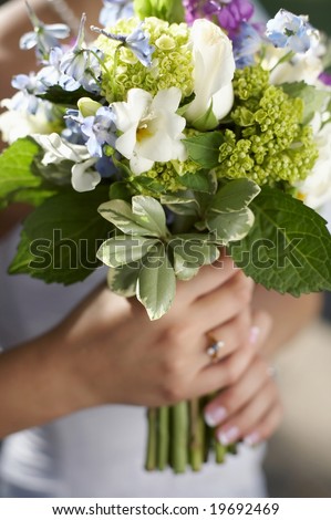 stock photo Bride holding wedding bouquet of white green and blue flowers