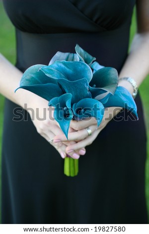 stock photo Bridesmaid holding blue wedding bouquet against dress