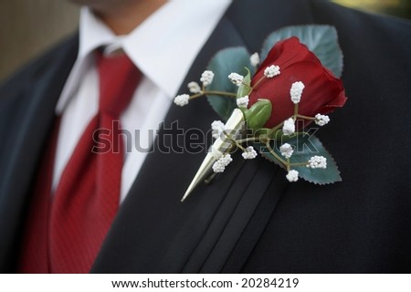 stock photo Classic red rose wedding boutonniere on suit of groom