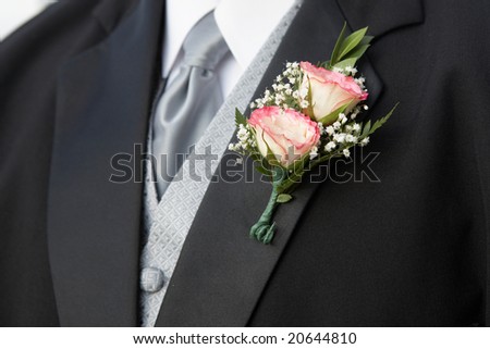 Pink rose wedding boutonniere on suit of groom