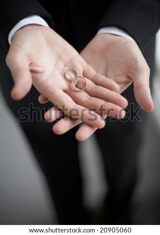 Hands holding wedding bands DOF focus on rings