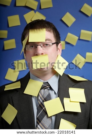 Businessman overwhelmed with yellow sticky reminder notes