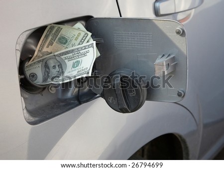 Rising gasoline prices concept money in gas tank