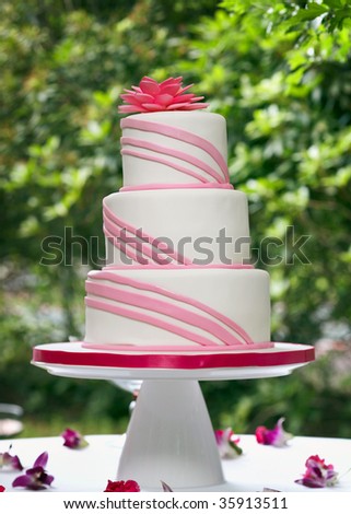 stock photo White and pink wedding cake on reception table outside