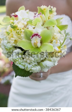 Bride holding colorful wedding bouquet against dress