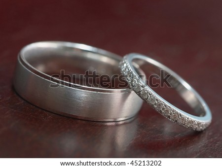 stock photo Pair of silver wedding rings on rosewood table 