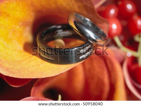 stock photo Two silver wedding rings on orange bouquet flower