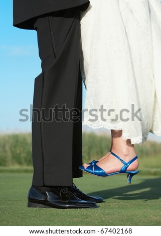 Groom lifting bride feet outside wedding