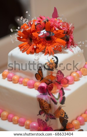 stock photo White wedding cake closeup with red and pink flowers