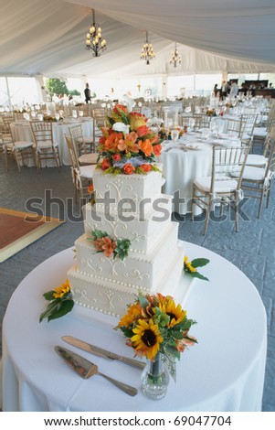 Wedding cake with flowers on table at reception