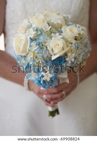 stock photo Bride holding wedding bouquet of white and blue flowers