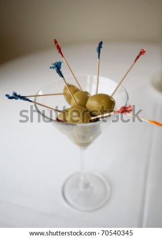Martini glass filled with olives on  restaurant table